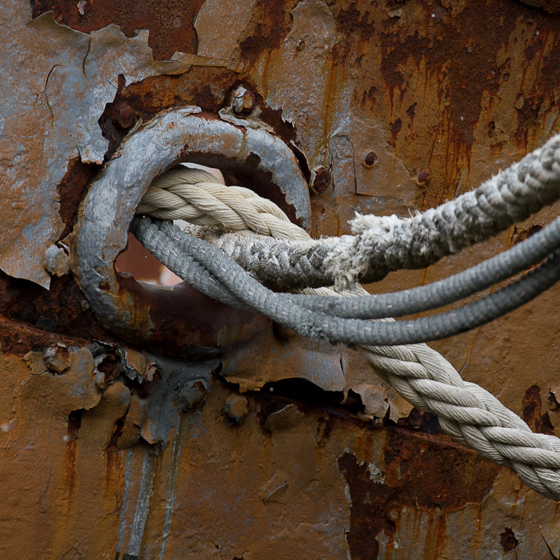 photo of rope and cables in a rusty ship wall