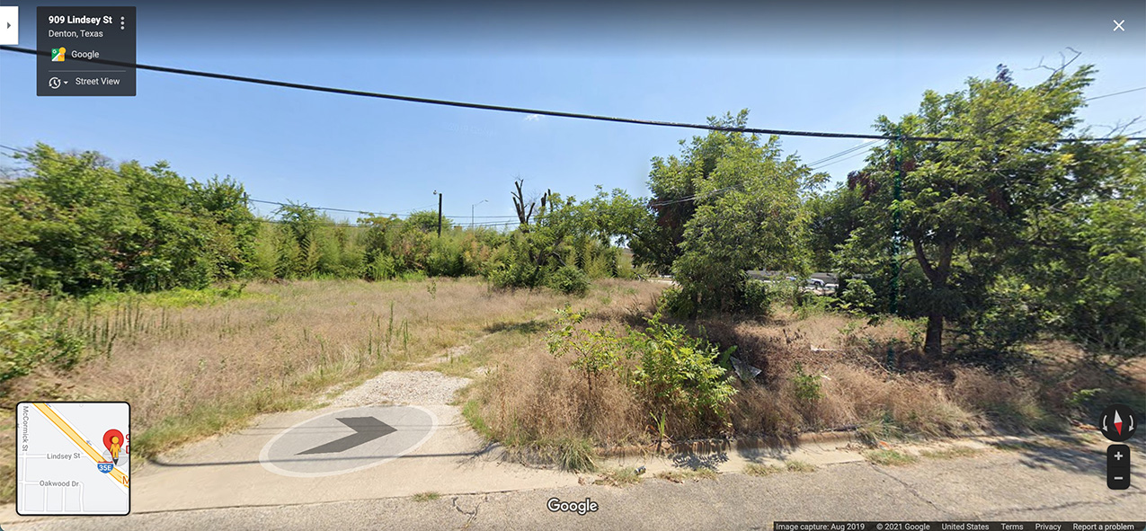 Google street view of the nonconforming lot showing some trees and dead grass
