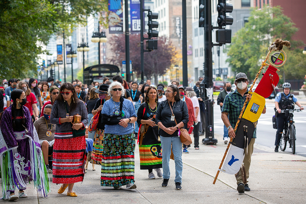 Photo of public art performance “Whose Lakefront” – participants include Native and non-Native people bringing attention to the area’s history of colonialism by walking in downtown Chicago 
