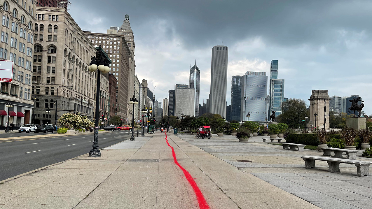 A line of red sand on the sidewalk in downtown Chicago, laid as part of the public art performance “Whose Lakefront” to bring attention to the area’s history of colonialism and specifically the land taken from the Pokagon Band of Potawatomi Indians