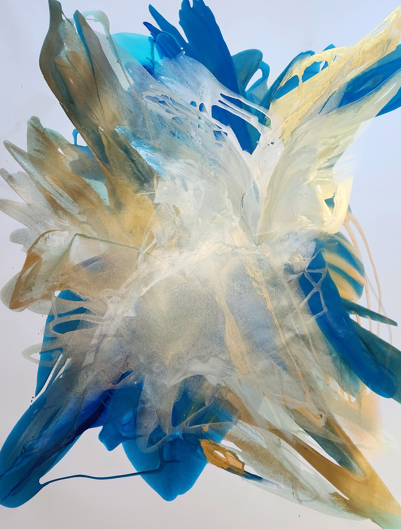 abstract poured painting in blue and gold over a light gray background; the thin layers of paint invoke movement and their transparency resembles layers of sheer fabric