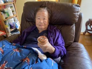 the author's Popo (Grandma) eating a cupcake in her brown recliner