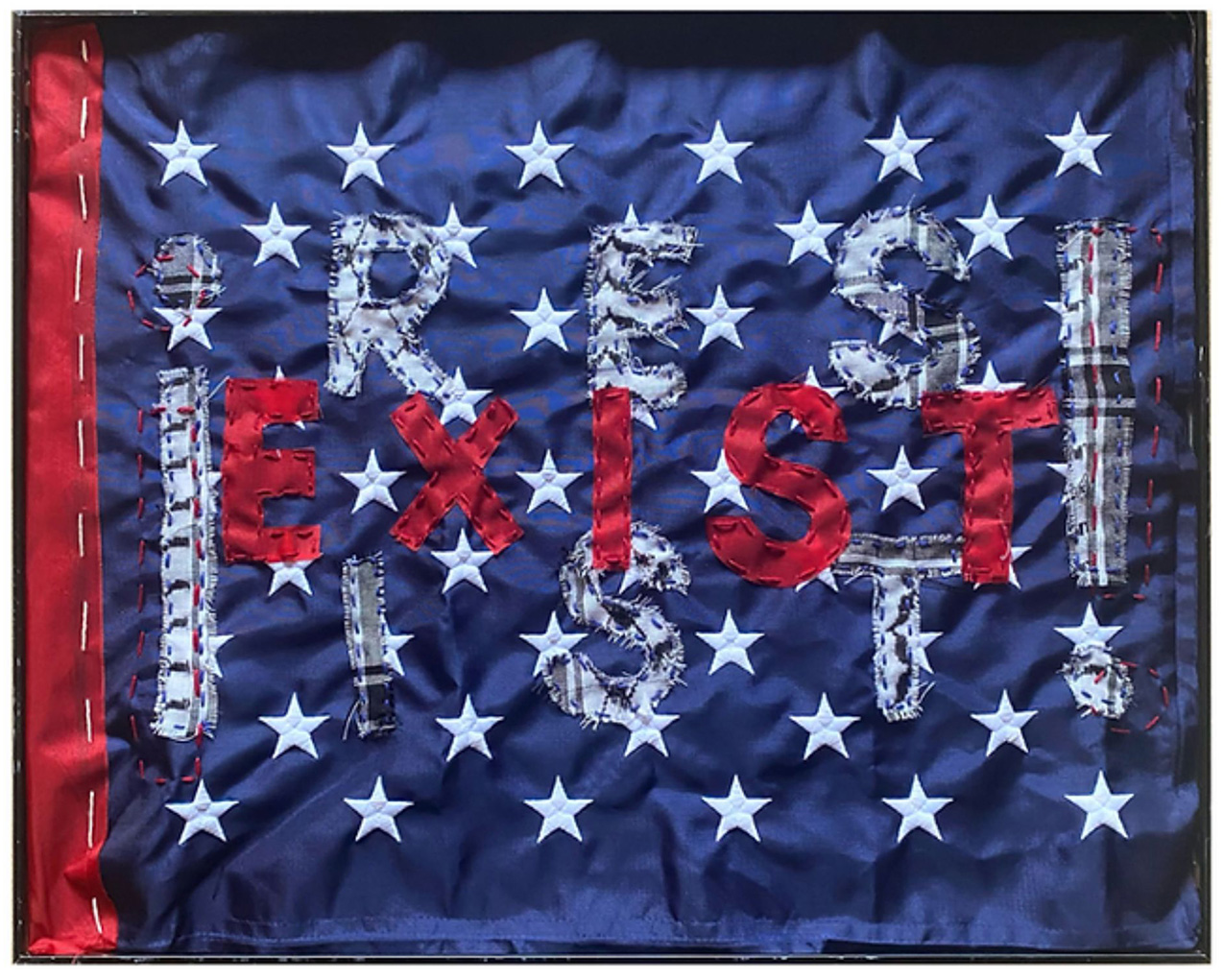 a field of blue fabric with white embroidered stars from a United States flag, with ¡RESIST! (gray and white fabric letters) and EXIST (red fabric letters) hand sewn on top