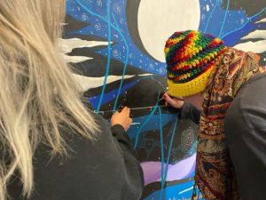 closeup of two artists working on a painting