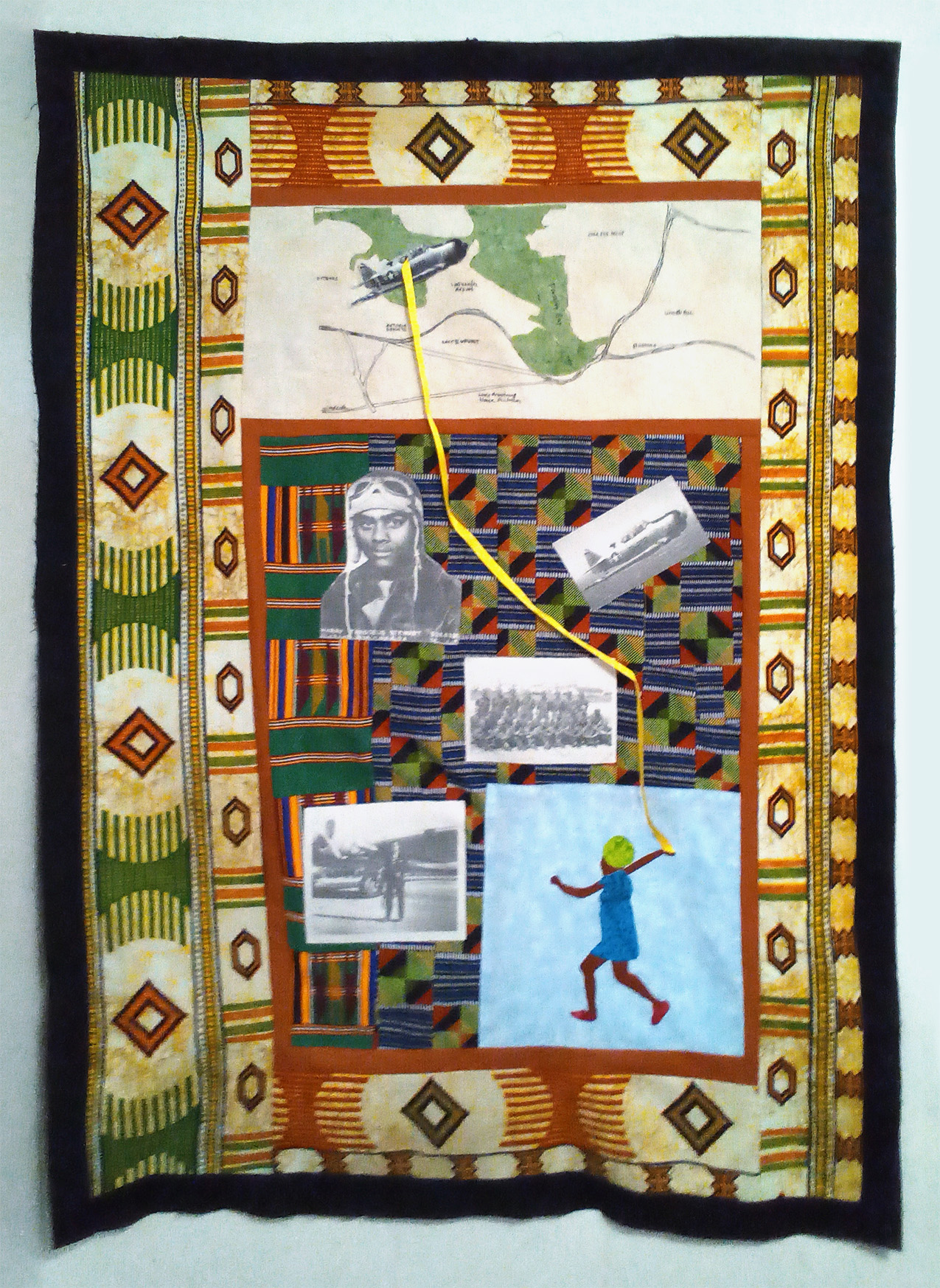an art quilt comprised of a thick black border; rust, green, orange, and blue-colored geometric fabrics mimicking Ghanaian cloth; a girl in the lower right running with a ribbon attached to a WWII plane flying over a hand-drawn map in the upper left; Tuskegee Airmen black and white photos