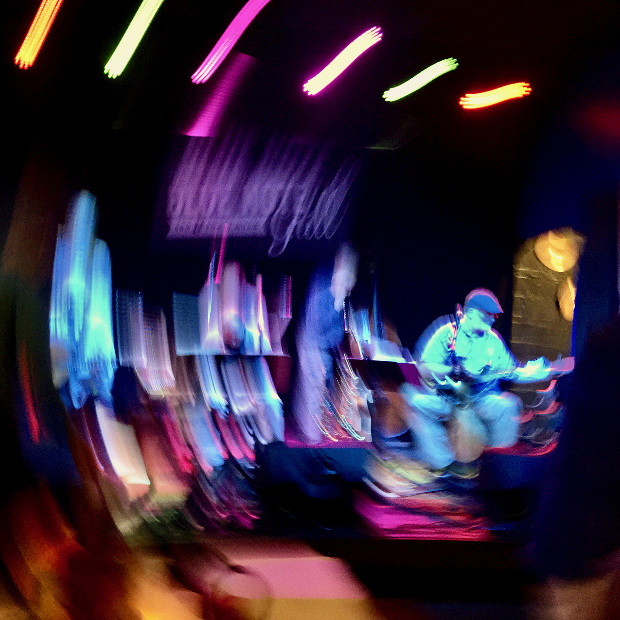 black and neon-colored photo of jazz musicians performing with a circular blur