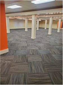 A large indoor gathering space with striped carpet squares