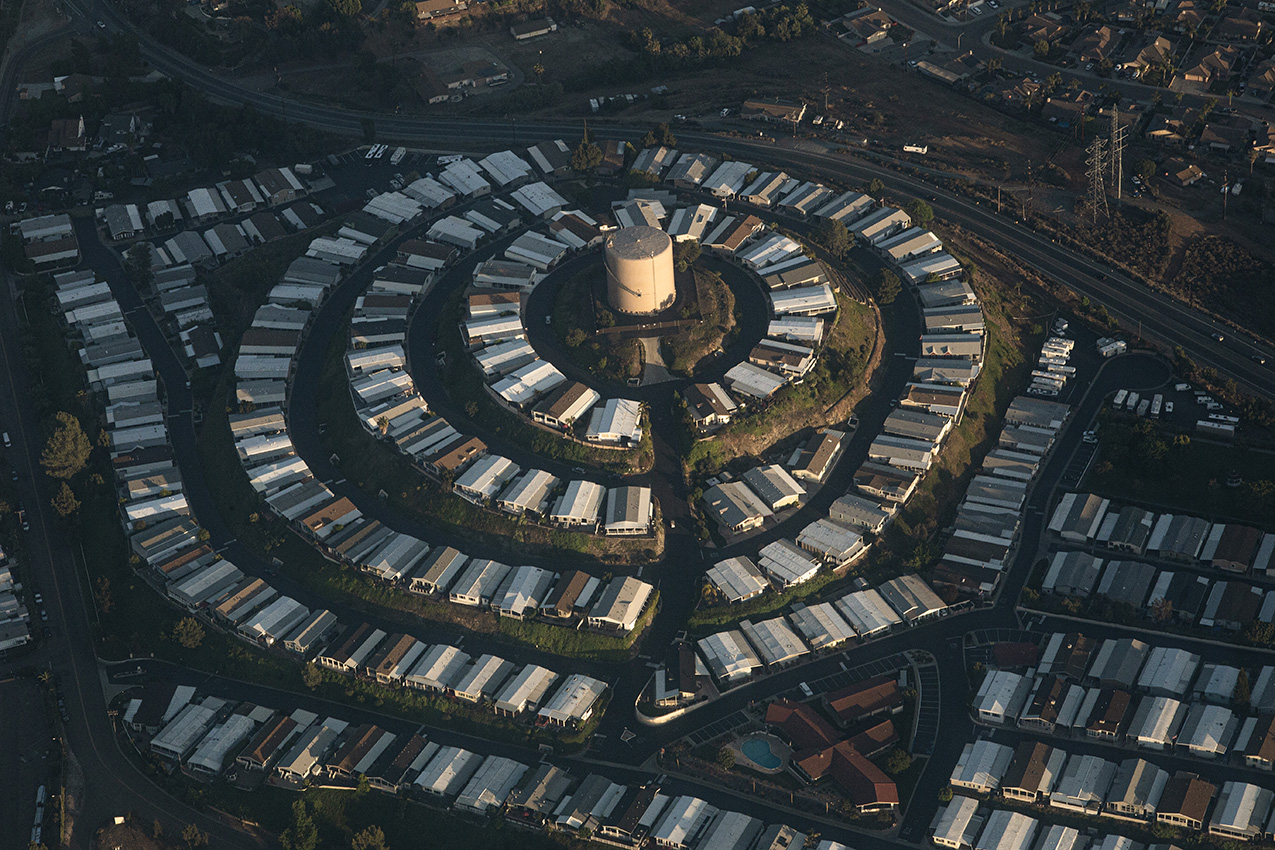 low-light aerial photo of tract housing following a circular pattern around a water tower