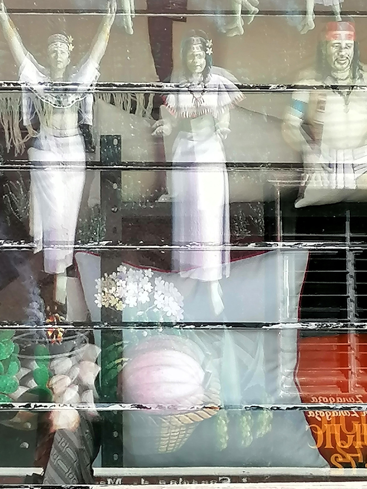 three Native American figures appear to float in a shop window with horizontal bars