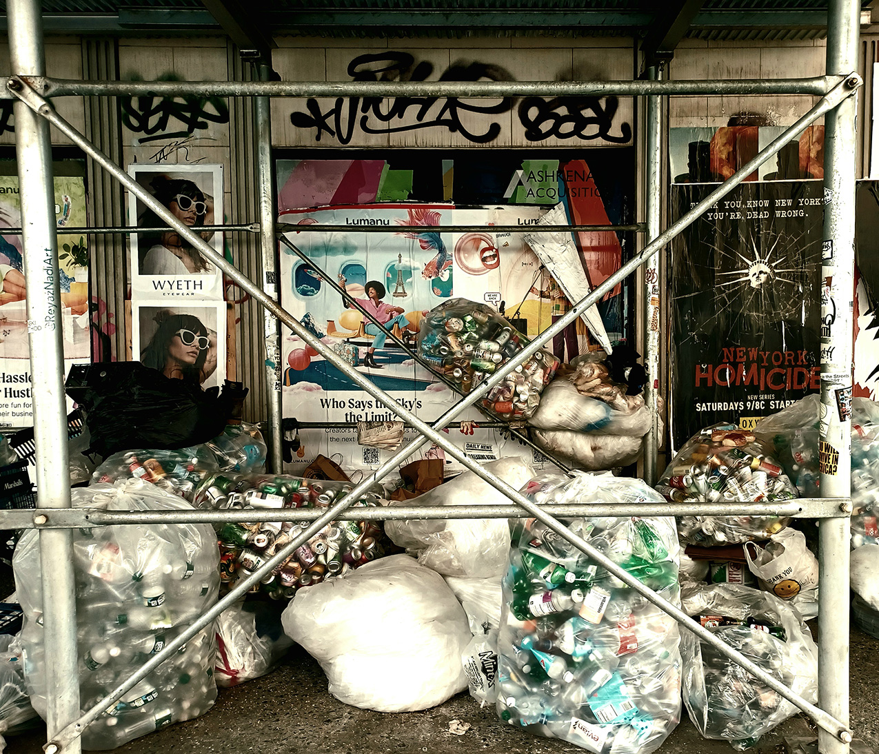 a high-contrast color photo of a space on a grungy city sidewalk framed by scaffolding; the walls are covered in peeling advertisements and graffiti, and the sidewalk is covered in clear plastic bags stuffed full of empty bottles and cans. near the center of the photo, the scaffolding covers part of an advertising slogan – the remaining visible text says "Who Says -ky's the Limit?"